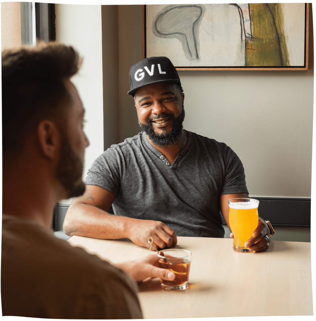 2 men having a drink at a table near the window at Fork and Plough