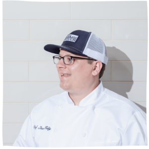 headshot of Chef Shawn Kelly against the white tile wall at Fork and Plough
